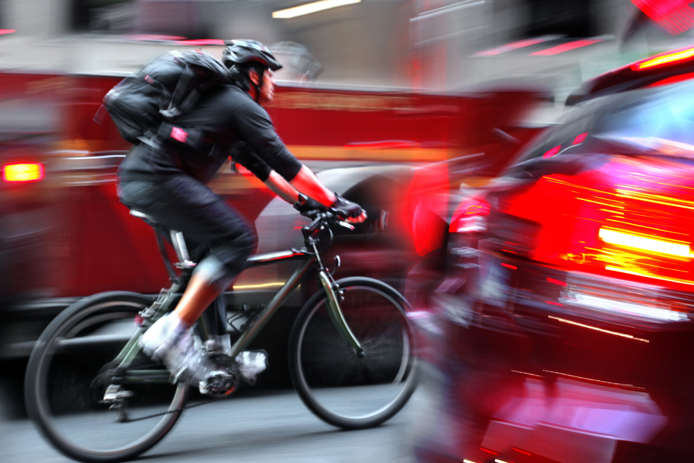 Urban Biker navigates through traffic in city road